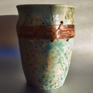 Teal and brown Raku pot with cherry bark weave by Ed Oldfield