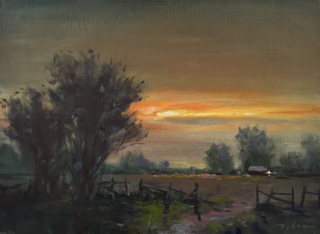 A band of light brilliantly glows across autumnal sky above a countryside home