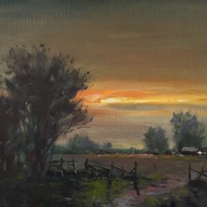 A band of light brilliantly glows across autumnal sky above a countryside home